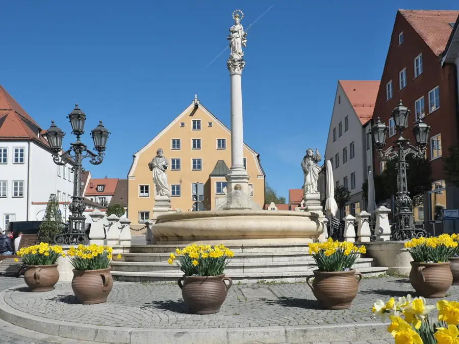 Mariensäule und Marienbrunnen mit Frühlingsblumen am Marienplatz in Friedberg