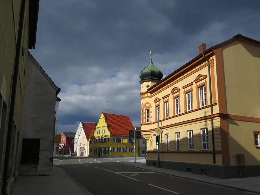 Straße in Thannhausen mit Zwiebelturm und bunten Häusern